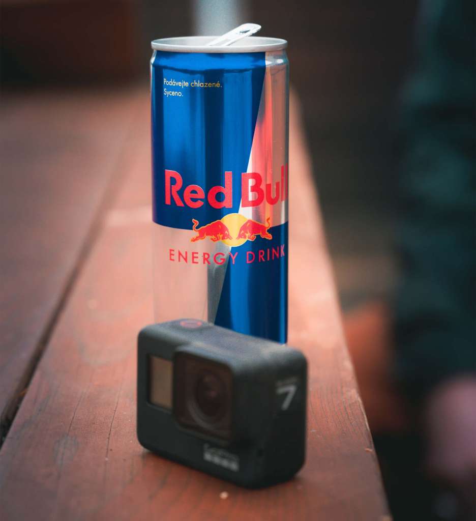 A GoPro camera and Red Bull can next to each other